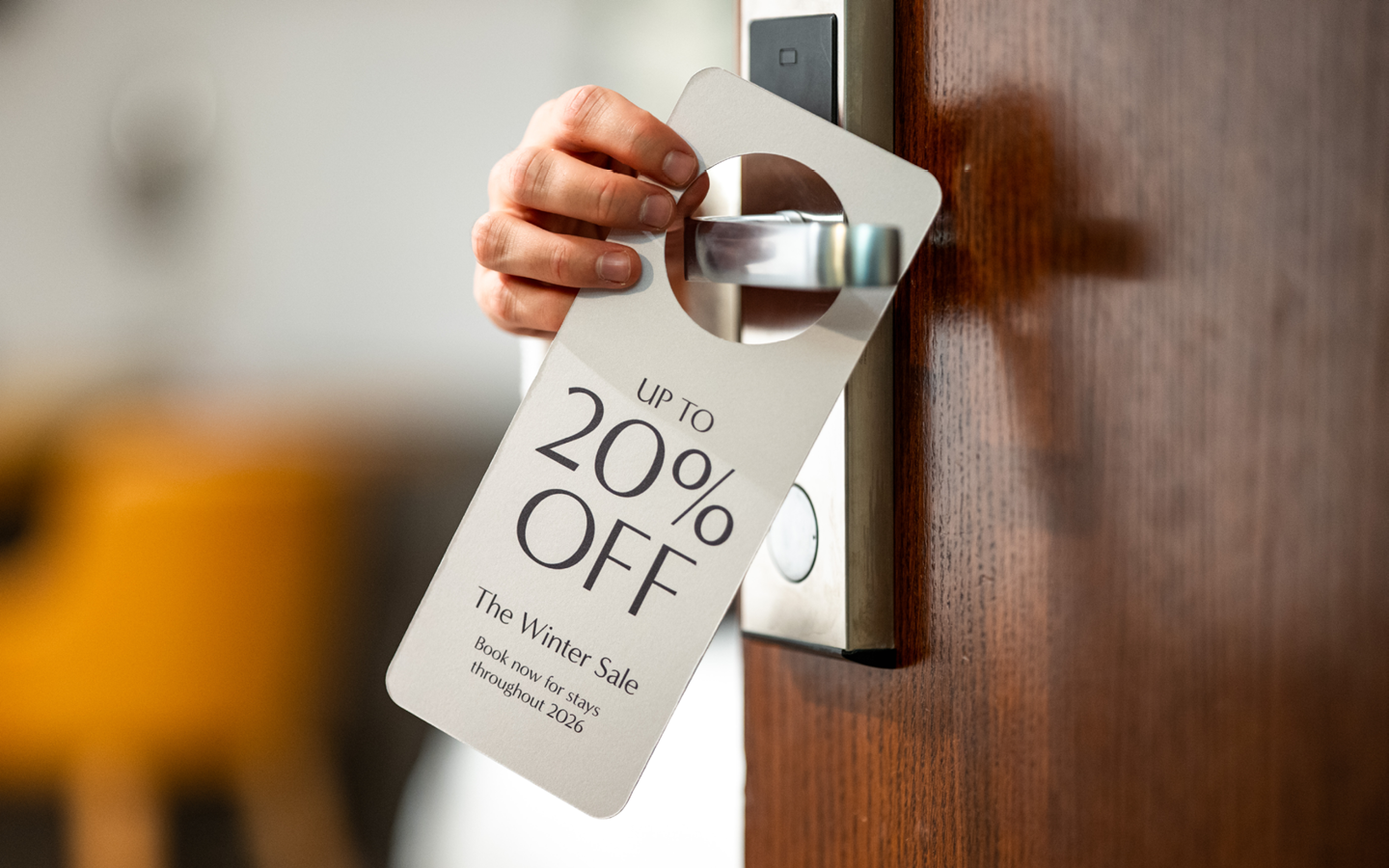 Door hanger on hotel door that reads "Up to 20% off"