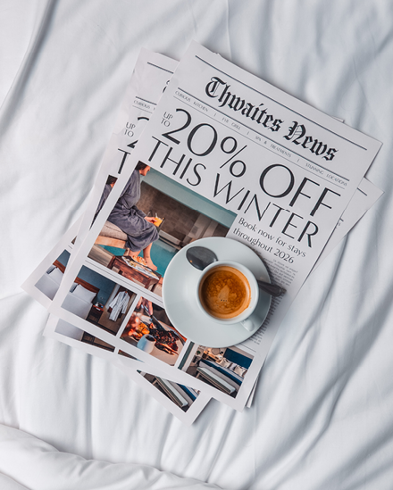 Newspaper on hotel bed with the headline "Up to 20% off winter sale"